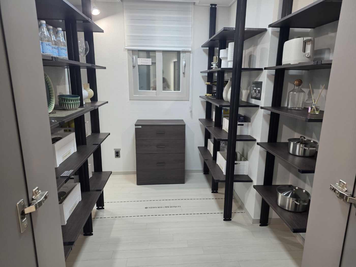 군산 경장 마루힐 써밋 견본주택 84A 타입 대형 팬트리의 양면 수납 선반과 발코니 확장 표시선